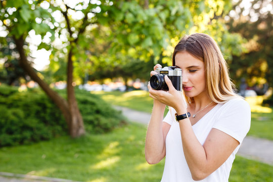 Young woman in park using her free time for photography
