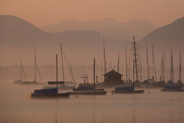 im Nebel ankernde Yachten vor den Alpen