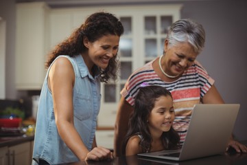 Happy family using laptop in kitchen