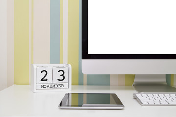 Cube shape calendar for NOVEMBER 23 and computer keyboard on table. 