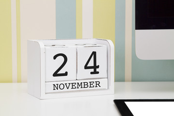Cube shape calendar for NOVEMBER 24 and computer keyboard on table. 