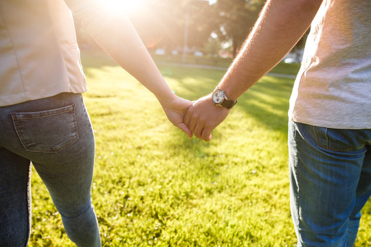 Young couple in love walking on sunny day  and holding their hands
