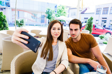 Beautiful friends taking selfie in caffe