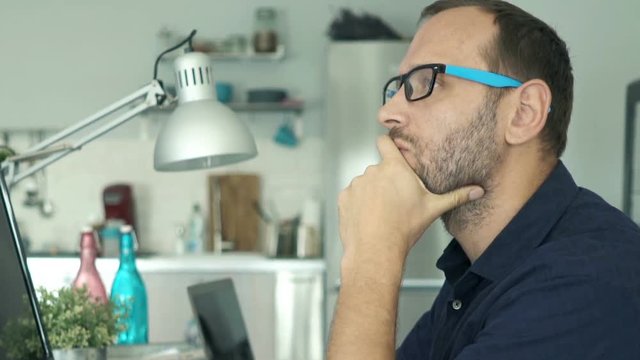 Young man with pc computer thinking, truing to solve problem at home