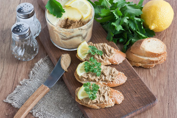 Chicken liver pate / Chicken liver pate with white bread, lemon, parsley on wooden cutting board