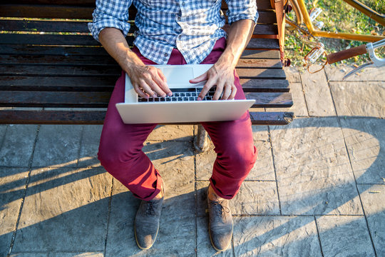 Top view male hands using notebook outdoors in urban setting while typing on keyboard