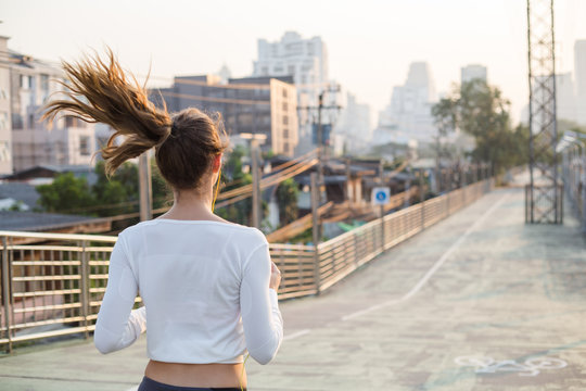 Woman Athlete Running On The Road In Morning Sunrise Training For Marathon 