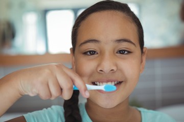 Girl brushing teeth in the bathroom