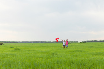 happy couple in love holding red balloon
