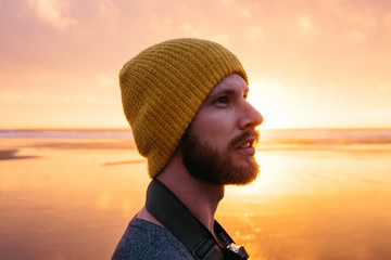 side profile portrait of young male at beach during sunset