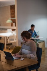 Female executive using digital tablet at desk