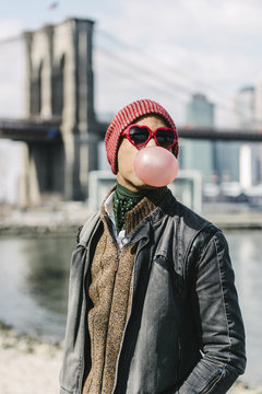 Blowing bubble gum, heart shaped glasses portrait in New York City