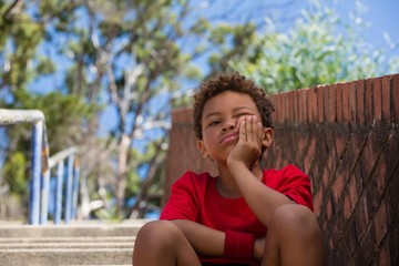 Upset boy sitting on staircase in the boot camp