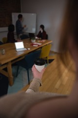Female executive holding coffee cup