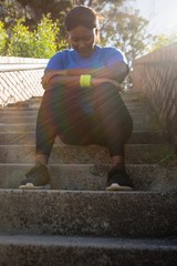 Upset woman sitting on staircase in the boot camp