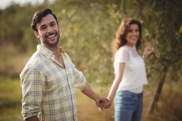 Obraz premium Handsome young man holding woman at olive farm