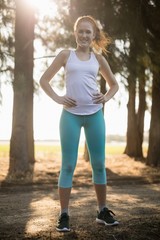 Portrait of smiling young woman standing on field