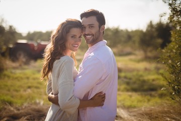 Portrait of smiling young couple embracing at olive farm