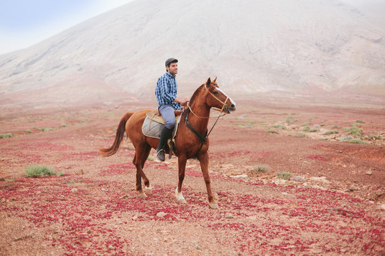 Man Riding a Horse in a Desert Area
