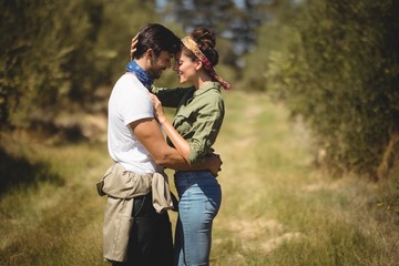Young couple embracing at olive farm on sunny day