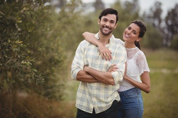 Portrait of young couple standing at olive farm