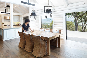 African American woman setting the table in dining room