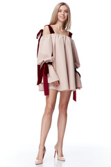 Sexy pretty fashion model blond hair woman wear style for party office clothes organic natural beige dress white background makeup lady perfect body shape shop magazine cover catalog collection.