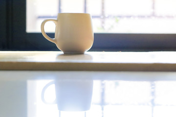 Coffee cup on wooden table with window background - vintage style effect picture