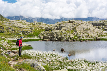 Naklejka premium Female trekker walking along mountain lake.