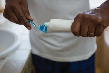Obraz na płótnie Canvas Mid section of man applying toothpaste on brush