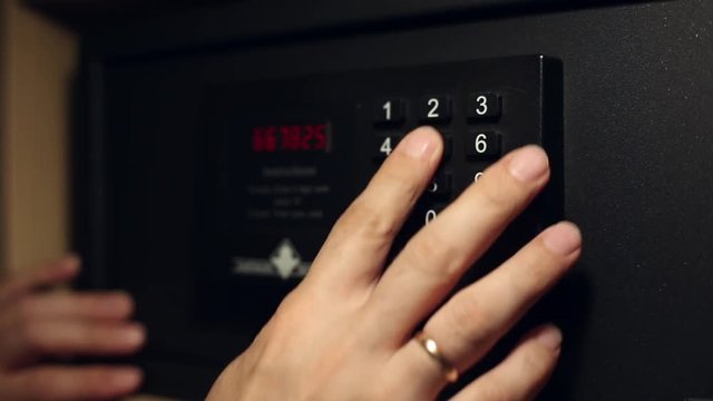 A man enters the secret code on a safe deposit box and opens the door