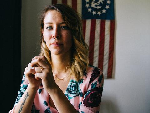 portrait of young female laughing in front of american flag 