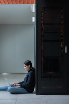 Female technician using computer in data center