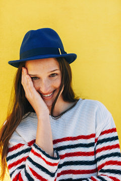 Portrait of young beautiful woman smiling in front of yellow background