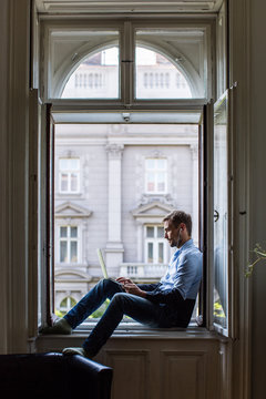 Man sitting at the window and working on a computer