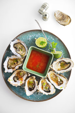 Oysters With Hot Sauce On White Background