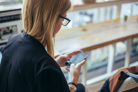 Blonde Woman Using Her Phone At The Coffee Shop