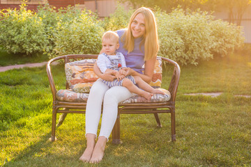 Obraz premium happy harmonious family outdoors. mother laughing and playing with baby in the summer on the nature