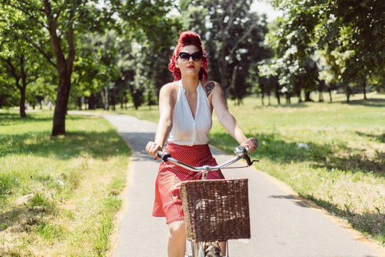 Young pin up woman riding a bicycle 