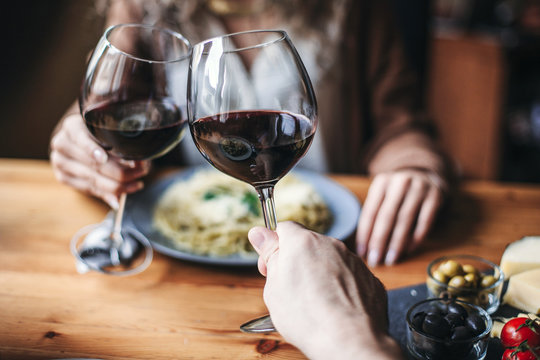 Couple Clinking Wine Glasses At The Table