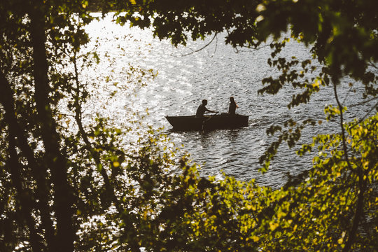 A romantic couple goes for a quaint row boat ride 