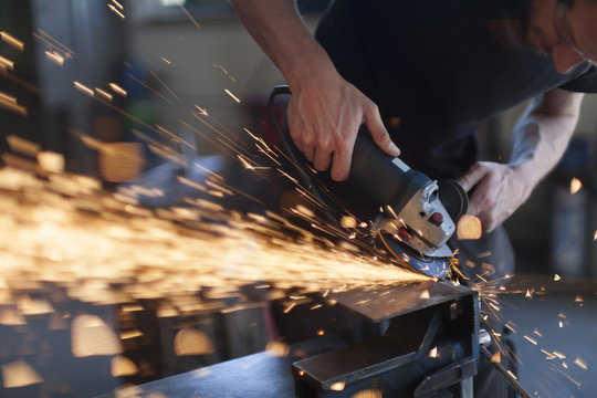 Blacksmith grinding in workshop