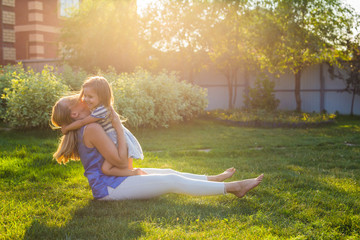 happy harmonious family outdoors. mother laughing and playing with baby daughter girl in the summer...