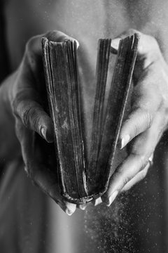 Hands of a woman opened a dusty old book