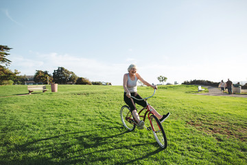 Vibrant mature woman enjoying herself on a bicycle