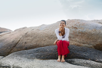 Smiling Senior Woman Sitting on a Rock