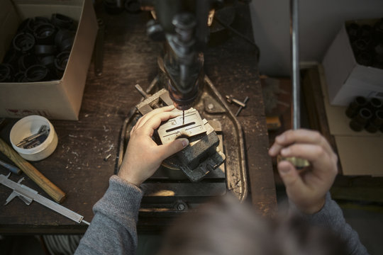 Man Drilling a Hole in a Metal Plate