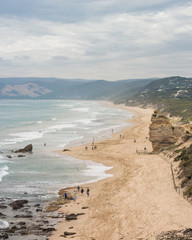 Long sandy beach with cliffs and gentle waves