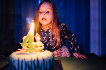 Girls blowing up a candle on her birthday cake
