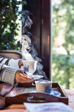 Woman drinking hot tea in bed on a winter day